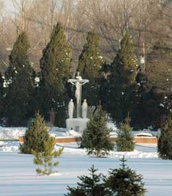 Morning light shines on Dec. 12 on a crucifix and other statuary in the snow-covered cemetery at Our Lady of Grace Monastery in Beech Grove. The Benedictine women’s religious community recently celebrated the 50th anniversary of its founding.