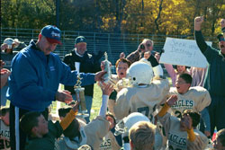 Roncalli High School head football coach Bruce Scifres presents both the championship trophy and the runner-up trophy to the players of Our Lady of the Greenwood Parish&rsquo;s third- and fourth-grade &ldquo;Green&rdquo; and &ldquo;Gold&rdquo; teams. The two teams met in the championship game of the 3/4 AA CYO tournament, a game that ended 0-0. (Photo courtesy David Matthews) 