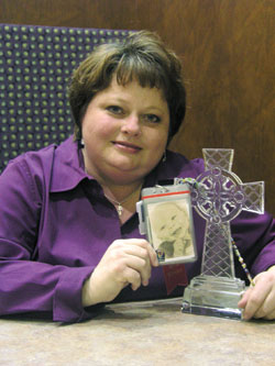 Ann Spitzig-Cady holds a photograph of her 1-year-old grandson, Serj, near a crystal cross&mdash;two Christmas gifts that have helped her through a difficult time.