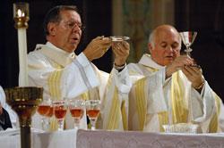 From left, Archbishop Daniel M. Buechlein and Father Gerald Kirkhoff, pastor of St. Pius X Parish in Indianapolis, pray the doxology at the end of the eucharistic prayer during a Mass in honor of St. Theodora Guérin celebrated on Nov. 29, 2006, at St. Joan of Arc Church in the Indianapolis North Deanery.
