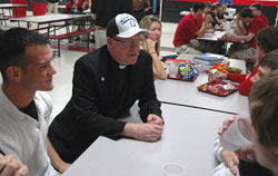 Father Peter Gallagher, the Colts&rsquo; chaplain, talks with students at Cardinal Ritter Jr./Sr. High School in Indianapolis on Jan. 22 -- the day after the Indianapolis Colts won the AFC Championship game. He is sporting the official championship hat given to him at the end of the game. (Photo by Sean Gallagher) 