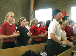 Seventh-grade students from St. Jude School in Indianapolis clap their hands during a hymn at the Jan. 24 Mass at St. Jude Church honoring St. Theodora Gu&eacute;rin. (Photo by Mike Krokos) 
