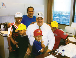 When Janice Knox adopted her niece&rsquo;s four sons in 2004, the boys asked to have their picture taken with the commissioner who approved the adoption. From left, Elijah, Tuskany, Janice, Israel and Jonathan share their celebration with Mark Battise, a commissioner for the Marion County Superior Court 8 Probate Division. (Submitted photo) 
