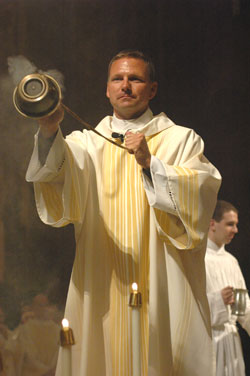 Deacon Eric Nagel incenses the priests during the chrism Mass on April 3 at SS. Peter and Paul Cathedral in Indianapolis. He believes his family&rsquo;s support and several miracles led him to say &ldquo;Yes&rdquo; to God&rsquo;s call to the priesthood. (Photo by Sean Gallagher) 