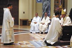 Benedictine Deacon Paul Nord stands before Archbishop Daniel M. Buechlein during the June 3 liturgy at Saint Meinrad Archabbey Church in St. Meinrad during which he was ordained a priest. Father Paul is a monk of Saint Meinrad Archabbey. To the left of the archbishop, watching the ritual are, from left, Benedictine Father Anthony Vinson and Benedictine Archabbot Justin DuVall. (Submitted photo)