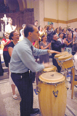 Joshua Stagni, the principal percussionist for the Notre Dame Folk Choir, plays the drums while the choir sings during the ensemble&rsquo;s July 10 concert at SS. Peter and Paul Cathedral in Indianapolis. The concert was a part of the July 9-13 convention of the National Association of Pastoral Musicians.
