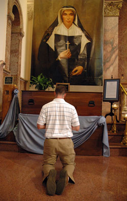 Seminarian Dustin Boehm, a member of Our Lady of the Greenwood Parish in Greenwood, kneels in prayer before the remains of St. Theodora Gu&eacute;rin during a seminarian pilgrimage on Aug. 15 in the Church of the Immaculate Conception at Saint Mary-of-the-Woods, the motherhouse of the Sisters of Providence.