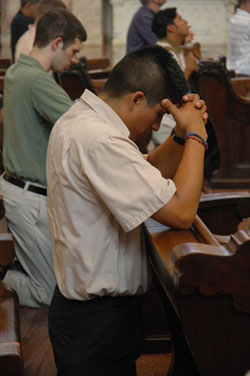 Seminarian Martin Rodriguez, a junior at Marian College in Indianapolis and a resident of the Bishop Simon Brut&eacute; College Seminary, prays on Aug. 15 at the Church of the Immaculate Conception on the grounds of the motherhouse of the Sisters of Providence of Saint&nbsp;Mary-of-the-Woods. Rodriguez helped organize an effort over the summer where eight seminarians and members of the Nigerian-based Daughters of Mary Mother of Mercy went door to door in the neighborhoods surrounding the Mother Theodore Catholic Academies to encourage families there to enroll their children in the schools.