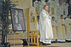 Archbishop Daniel M. Buechlein stands next to a framed portrait of Blessed Teresa of Calcutta at the start of a Mass commemorating the 10th anniversary of her death that was celebrated on Sept. 5 at SS.&nbsp;Peter and Paul Cathedral in Indianapolis.