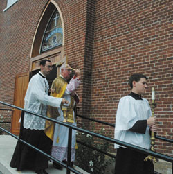Priestly Fraternity of St. Peter Father Gerard Saguto elevates the host at the solemn Mass celebrated on Sept. 6 at SS. Philomena and Cecilia Church in Oak&nbsp;Forest after archdiocesan vicar general Msgr. Joseph F. Schaedel solemnly blessed the church. Father Saguto is being assisted by Priestly Fraternity of St.&nbsp;Peter Father Mark Wojdelski and Priestly Fraternity of St. Peter Father Father Michael Magiera.