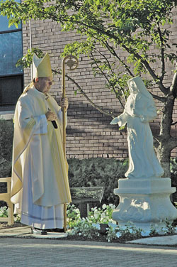 Archbishop Daniel M. Buechlein stands in prayer on Sept. 12 after blessing a statue of St.&nbsp;Theodora Gu&eacute;rin in the courtyard at St.&nbsp;Joseph University Church in Terre Haute.	