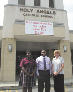 Smiles mark the celebration at Holy Angels School for its 100th anniversary. Student Mya Terrell, left, poses with the school&rsquo;s campus director, Michael Joseph, and principal, Cindy Greer.