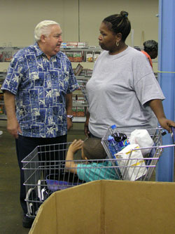 Jake Asher, left, takes the time to talk with Jenean Hoskin and her grandson, Daniel, sitting in the shopping cart. As the president of the Indianapolis Council of the Society of St. Vincent de&nbsp;Paul, Asher supervises the Pratt-Quigley Center which offers free food, medical care and legal assistance to people in need.