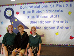 St. Pius X seventh-grade students, from left, Gabby LaFrance, Gabrielle Nondorf and Emily Lux, pose in front of a poster proclaiming the Indianapolis school&rsquo;s selection as a 2007 Blue Ribbon School of Excellence by the U. S. Department of Education. (Submitted photo) 
