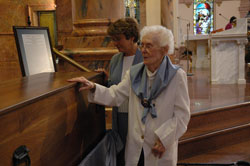 Providence Sister Marie Ellen Sullivan, a retired sister who lives at the motherhouse, and St.&nbsp;Patrick parishioner Teresa Clark of Terre Haute venerate the remains of St. Theodora Gu&eacute;rin after the saint&rsquo;s first feast day Mass on Oct. 3 at the Church of the Immaculate Conception at Saint Mary-of-the-Woods. Clark is the artist who created the official sculpture of the eighth&nbsp;American saint. It has been reproduced in several sizes.