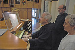 Benedictine Father Harry Hagan and Providence Sister Regina Marie McIntyre look on as Benedictine Father Prior Tobias Colgan plays the tune he composed for the hymn text in honor of St. Theodora Gu&eacute;rin written by Father Harry. Father Tobias played the tune on Oct. 3, St. Theodora&rsquo;s feast day, on the organ of the Archabbey Church of Saint&nbsp;Meinrad Archabbey in St. Meinrad, where he and Father Harry are members.