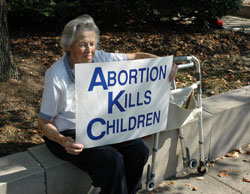 St. Andrew the Apostle parishioner Mary Jane Dye of Indianapolis sits in the shade during the Central Indiana Life Chain on Oct.&nbsp;7 in Indianapolis. Temperatures climbed to 90 degrees on Respect Life Sunday. She and her husband, John, participate in the one-hour Life Chain prayer vigil every year.