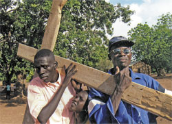 Head catechist Damiasio Ding, left, and Lorenze Makatatu carry the cross during a Lenten procession at St. Theresa Parish in Nyamllel in southern Sudan last year. Lay catechists help Comboni Father Michael Barton, the parish&rsquo;s pastor, teach the Catholic faith to people in the Diocese of Rumbek. Three Indonesian sisters who are members of the Daughters of Our Lady of the Sacred Heart order and lay teachers help Father Barton at four Comboni schools in Nyamllel. Students study English, Dinka, Swahili, Arabic, science, agriculture, geography, civics, history and religious education. (Submitted photo) 