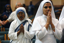 Missionaries of Charity Sister M. Sumati, left, and Franciscan Sisters of the Immaculate Heart of Mary Sister Sabeena Mary pray during the World Mission Sunday Mass on Oct. 21 at SS.&nbsp;Peter and Paul Cathedral in Indianapolis.
