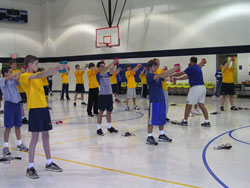 Mike Prior, Indianapolis Colts youth football commissioner, right, demonstrates an exercise to St.&nbsp;Anthony of Padua School eighth-grade students during the Colts Fitness Camp session on Nov. 27.	