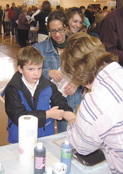 Anthony Treash, a third-grade student at St. Mary School in Greensburg, leaves his &ldquo;lasting impression&rdquo; while his mother, Gina, and sister, Sara, wait their turn.