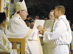 In a gesture symbolic of his promise of obedience, Deacon&nbsp;Rick Nagel places his hands in the hands of Archbishop Daniel M. Buechlein of Indianapolis during a June 2 ordination Mass at SS. Peter and Paul Cathedral in Indianapolis. Deacons Thomas Kovatch and Randall Summers were also ordained during the liturgy. (Photo by Sean Gallagher) 