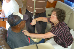 Registered nurse Connie Herr looks at her watch to track the heart rate of a patient seeking care through the Gennesaret Free Clinics, a volunteer organization started by Dr. Jim Trippi, a&nbsp;member of St.&nbsp;Thomas Aquinas Parish of Indianapolis. (Submitted photo)	