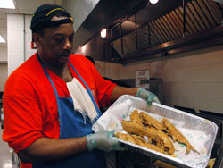 Holy Angels parishioner Reggie Ash of Indianapolis displays a tray of &ldquo;whole cats,&rdquo; breaded catfish that he deep-fried during the Indianapolis West Deanery parish&rsquo;s Lenten fish fry on Feb. 8 at the Holy Angels School cafeteria. (Photo by Mary Ann Wyand)	
