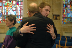 Seminarian Andrew Proctor, in his fourth year at&nbsp;the Bishop Brut&eacute; College Seminary at Marian&nbsp;College in Indianapolis, exchanges the Sign of Peace with his father, David Proctor, a member of Our Lady of the Greenwood Parish in Greenwood. (Photo by Sean Gallagher)	