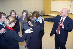 Marian College speech and debate coach the Rev. George LaMaster, right, prays with his team before a tournament at Ball State University in Muncie, Ind., in October 2007. &ldquo;I never thought I&rsquo;d have a speech team where I could start a competition with a prayer. That&rsquo;s a wonderful thing,&rdquo; LaMaster said. &ldquo;It gives a character to the whole experience. It holds the competition in perspective.&rdquo; (Submitted photo)	