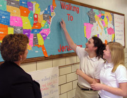 At Holy Spirit School in Indianapolis, sixth-grade student Rachel Clark, middle, tracks the progress of her team&rsquo;s path in &ldquo;Walking to Jerusalem,&rdquo; a 6,236-mile journey that the school community is making as a Lenten journey. Principal Rita Parsons, left, and seventh-grade student Lindsey Newhart also examine the map. (Photo by John Shaughnessy) 