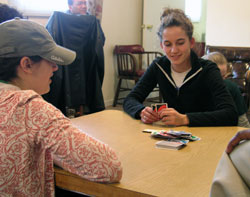 Alyssa Grengs, left, and Anna Peterson play a card game with children at Miracle Place, an Indianapolis center operated by Providence sisters that helps at-risk students, senior citizens and Hispanic people. Grengs and Peterson are Creighton University students who spent their spring break in &shy;Indianapolis working to make a difference in the lives of others. (Photos by John Shaughnessy) 