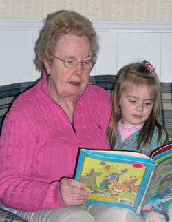 A mother of eight grown children, Carolyn Mueller was recently honored by Indianapolis television station WFYI as a 2008 Child Care Provider of the Year for the care and love she has given to her &ldquo;second family&rdquo; of children for the past 34 years. A member of Christ the King Parish in Indianapolis, Mueller reads a book to 3-year-old Maggie Smith. (Photo by John Shaughnessy) 