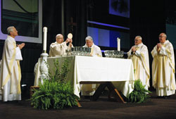 Archbishop Daniel E. Pilarczyk of Cincinnati elevates the Eucharist on March 25 during the opening Mass of the National Catholic Educational Association&rsquo;s annual convention at the Indiana Convention Center in Indianapolis. Also concelebrating at the altar are, from left, Archbishop Donald W. Wuerl of Washington, Bishop John M. D&rsquo;Arcy of Fort Wayne-South Bend, Ind.; Bishop Gerald A. Gettelfinger of Evansville, Ind.; and Msgr. Joseph F. Schaedel, vicar general of the Archdiocese of Indianapolis. (Photo by Sean Gallagher) 