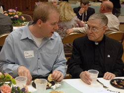 Seminarian Tim Wyciskalla, left, a sophomore at Bishop&nbsp;Simon Brut&eacute; College Seminary in Indianapolis, and retired Father Patrick Commons, talk on May 7 during a reception for members of the Miter&nbsp;Society at the Archbishop O&rsquo;Meara Catholic Center. The generosity of Miter Society members and other Catholics across the archdiocese supports priestly formation for seminarians and the needs of retired priests. (Photo by Sean Gallagher)