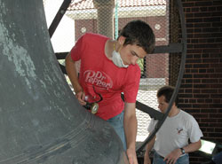 Our Lady of the Most Holy Rosary parishioners Ryne Friederick, left, and his father, Jerry, of Indianapolis begin restoration work on the bronze surface of the 7,000-pound San Salvador bell in the west belfry at the historic Italian church in Indianapolis on May 31. Ryne completed his Eagle Scout project in time for Holy Rosary Parish&rsquo;s 25th annual Italian Street Festival on June 13-14. (Photo by Mary Ann Wyand)