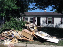 Debris lines a street in front of a flood-damaged home on June 12 in Columbus. Approximately 2,500&nbsp;homes in the city were damaged by floods on June 6-7. Members of St. Bartholomew Parish in Columbus responded quickly to give aid to fellow parishioners and others affected by the flood. (Photo by David Siler)