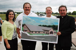 Project architect Diane Guljas of Sebree Architects Inc. stands with, from left, Nova Gilliatte, superintendent of Eden Enterprises; Stan Schutz, president of Eden Enterprises; and Father Glenn O&rsquo;Connor, pastor of St. Ann and St. Joseph parishes in Indianapolis, with an architectural rendering of the new St. Ann Church after the June 29 groundbreaking ceremony. Eden Enterprises will build the new church and social hall, which will be completed in early 2009. (Photo by Mary Ann Wyand) 