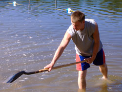 Bryce Denning, a member of St. Meinrad Parish in St.&nbsp;Meinrad, helps reclaim a beach on a pond in an interdenominational center for troubled youths in Michigan while participating in &ldquo;Service Week.&rdquo; The mission trip was sponsored by St. Robert of Newminster Parish in Ada, Mich., and brought in nearly 150 youths from several dioceses during late July. (Submitted photo) 