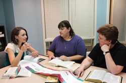 Using a Bible timeline chart, Alexa Puscas, left, director of religious education at St. Pius X Parish in Indianapolis, discusses the meaning of a Scripture passage on Sept. 3 with parishioners Calli Eickhoff, center, and Kathy&nbsp;Loeffler. Eickhoff is a financial assistant at the Indianapolis North Deanery parish and Loeffler is the parish secretary. They participated in The Great Adventure Bible Study Timeline last spring. (Photo by Mary Ann Wyand) 