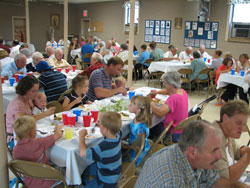 Members of St. Charles Borromeo Parish in Milan in the Batesville Deanery share a meal together on Aug. 23 after a Mass that celebrated the 100th anniversary of the parish&rsquo;s founding. (Submitted photo) 