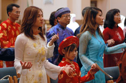 St. Joseph parishioners Jennie Le, from left, Anna Le and Celina Le of Indianapolis hold hands for the Lord&rsquo;s Prayer during the archdiocesan World Mission Sunday Mass on Oct. 19 at SS. Peter and Paul Cathedral in Indianapolis. They participate in the Vietnamese Apostolate at St.&nbsp;Joseph Parish in the Indianapolis West Deanery. (Photo by Mary Ann Wyand) 