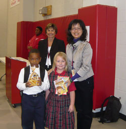 St. Joan of Arc School students Jalen Love, left, and Marianne Gaebler come bearing gifts for Liu Shu-Chen, right, a principal from Taiwan who visited the north-side Indianapolis school on Oct. 14-15. St. Joan of Arc principal Mary Pat Sharpe also welcomes Liu. Liu&rsquo;s visit to St. Joan of Arc School was arranged by the Indiana Department of Education as part of its international exchange project to build friendship and cooperation between schools in Indiana and Taiwan. (Submitted photo) 