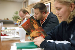 Julie Lasher, a student at Marian College in Indianapolis, reads from a book by the late Father Luigi Guissani, the founder of the international Catholic&nbsp;lay movement Communion Liberation, during a Nov. 9 &ldquo;School of Community&rdquo; meeting at the Ruth Lilly Student Center on Marian&rsquo;s campus. Listening to Lasher are, from left, Filippo Pattacinni and Rick Rush. (Photo by Sean Gallagher) 