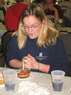 Kelsey Wilson of St. Thomas More Parish in&nbsp;Mooresville prays before eating her dessert&nbsp;during the trip to New York to see Pope&nbsp;Benedict XVI in April. (Submitted photo) 