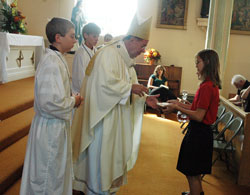 Archbishop Daniel M. Buechlein receives offertory gifts on Sept. 7, 2008, at St. Paul Church in New&nbsp;Alsace from Ryley Stonebreaker, a sixth-grader at the parish school, and (not seen) Gabby Meyer, a fifth-grader at the school, during a Mass that celebrated the 175th anniversary of the founding of St.&nbsp;Paul Parish. Assisting Archbishop Buechlein are altar servers Matthew Horner, left, and Andy&nbsp;Galle, both former St. Paul School students. This year, St. Paul School is starting its 175th&nbsp;consecutive year in operation. (File photo by Sean Gallagher) 