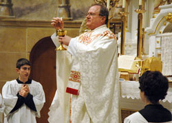 Priestly Fraternity of St. Peter Father Michael Magiera, associate pastor of Our Lady of the Most Holy Rosary Parish in Indianapolis, celebrates the traditional Latin Mass on Feb. 18 at the parish&rsquo;s church. Altar server Simon Sheridan, a student at Lumen Christi School, kneels at left. (Photo by Sean Gallagher) 