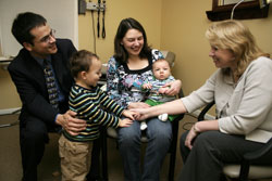 Dr. Melanie Margiotta, right, holds the hand of Benjamin Lam, second from left, while his parents, Carlos and Judy Lam, and his little brother, Oliver, visit Margiotta on Feb. 11 at her office in Indianapolis. Margiotta is the &ldquo;NFP-only&rdquo; family physician for the Lam family. Another NFP-only physician, who received training at the Pope Paul VI Institute in Omaha, Neb., successfully corrected Judy&rsquo;s endometriosis, which had caused infertility. (Photo by Sean Gallagher) 