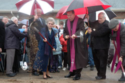 Archbishop Daniel M. Buechlein and Franciscan Sister Shirley Gerth, parish life coordinator of St. Anne Parish in New Castle, break ground for the new $4.4 million church on March 29 with help from, left to right, St. Anne parishioner Jack Basler, building committee chair, back to camera; New&nbsp;Castle Mayor James Small; Michael Witka, director of risk management for the archdiocese; and Father Joseph Rautenberg, sacramental minister for the Henry County faith community. (Photo by Mary Ann Wyand) 