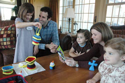 Steve and Joni Abdalla, second and fourth from left, play with their daughters, from left, Emma, Ruth and Vivian in their home in Indianapolis on April 1. The family is playing with the &ldquo;My Mass Kit,&rdquo; the first toy of the Abdalla&rsquo;s Catholic toy company, Wee Believers. The Abadallas are members of Our Lady of the Most Holy Rosary Parish in Indianapolis. (Photo by Sean Gallagher)